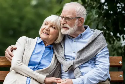 Rentnerpaar sitzt auf einer Bank im Park und geniesst ihre freie Zeit